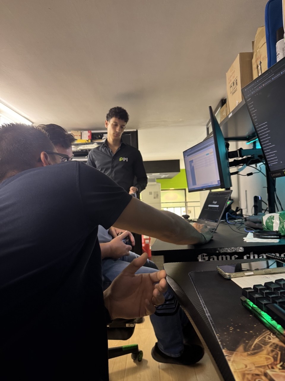 Team PowerMedia riunito intorno a una postazione di lavoro